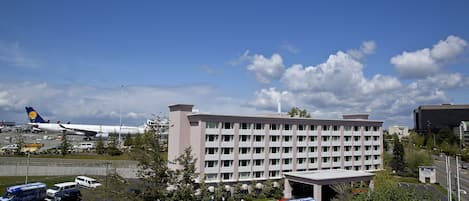 A multi-story hotel with a parking lot in front.