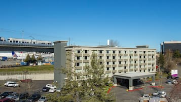 A multi-story hotel with a parking lot in front.