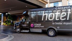 A black shuttle bus with "Coast Gateway Hotel" and "Closest Hotel to Seatac Airport" written on its side.