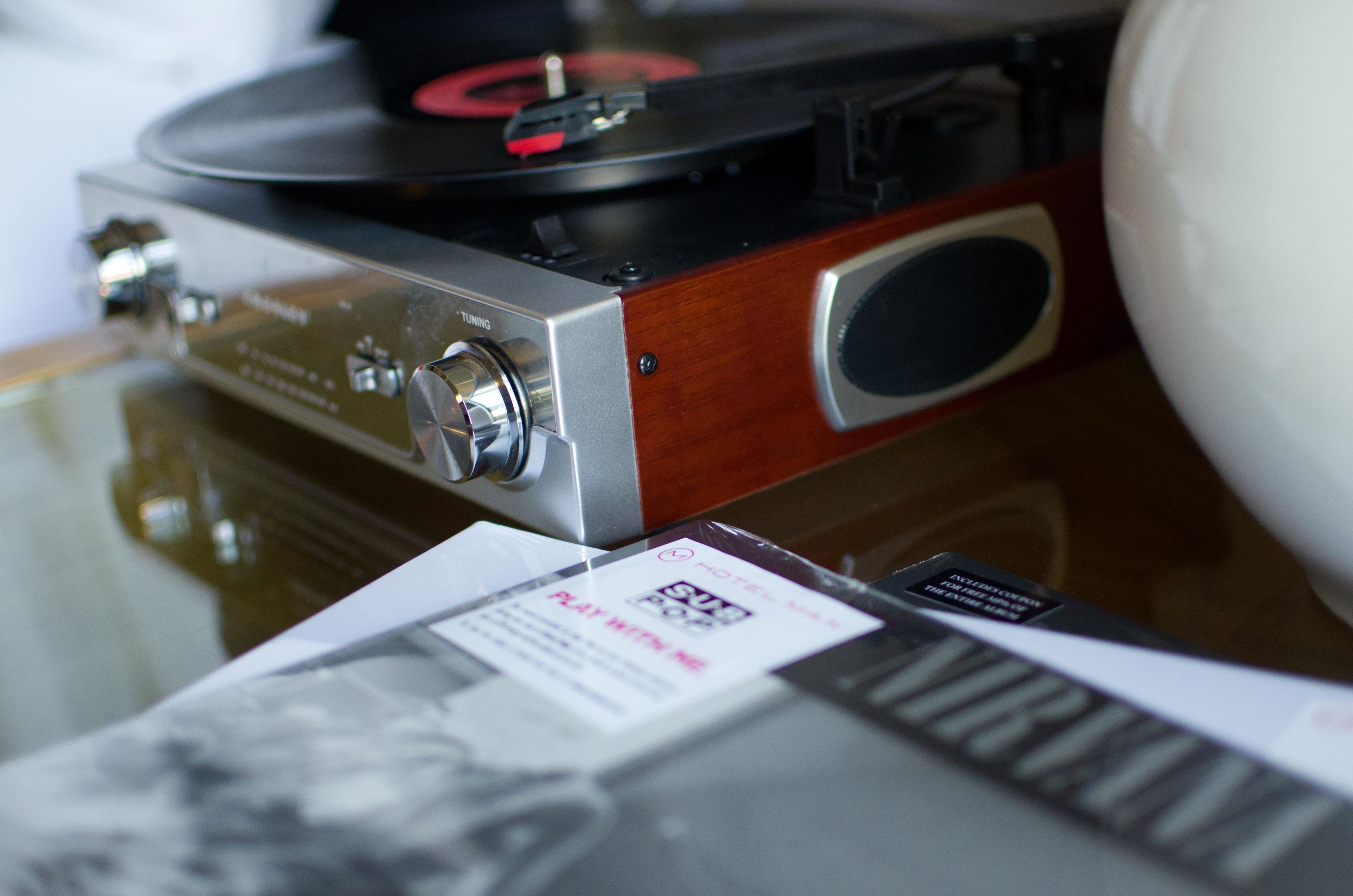 A turntable with a wooden finish and a metallic front panel.