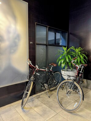 A bicycle parked next to a door with a potted plant beside it. - Hotel Max (Seattle)