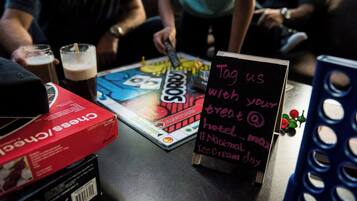 A table with a board game, a box of cereal, and a sign asking to tag with a treat.