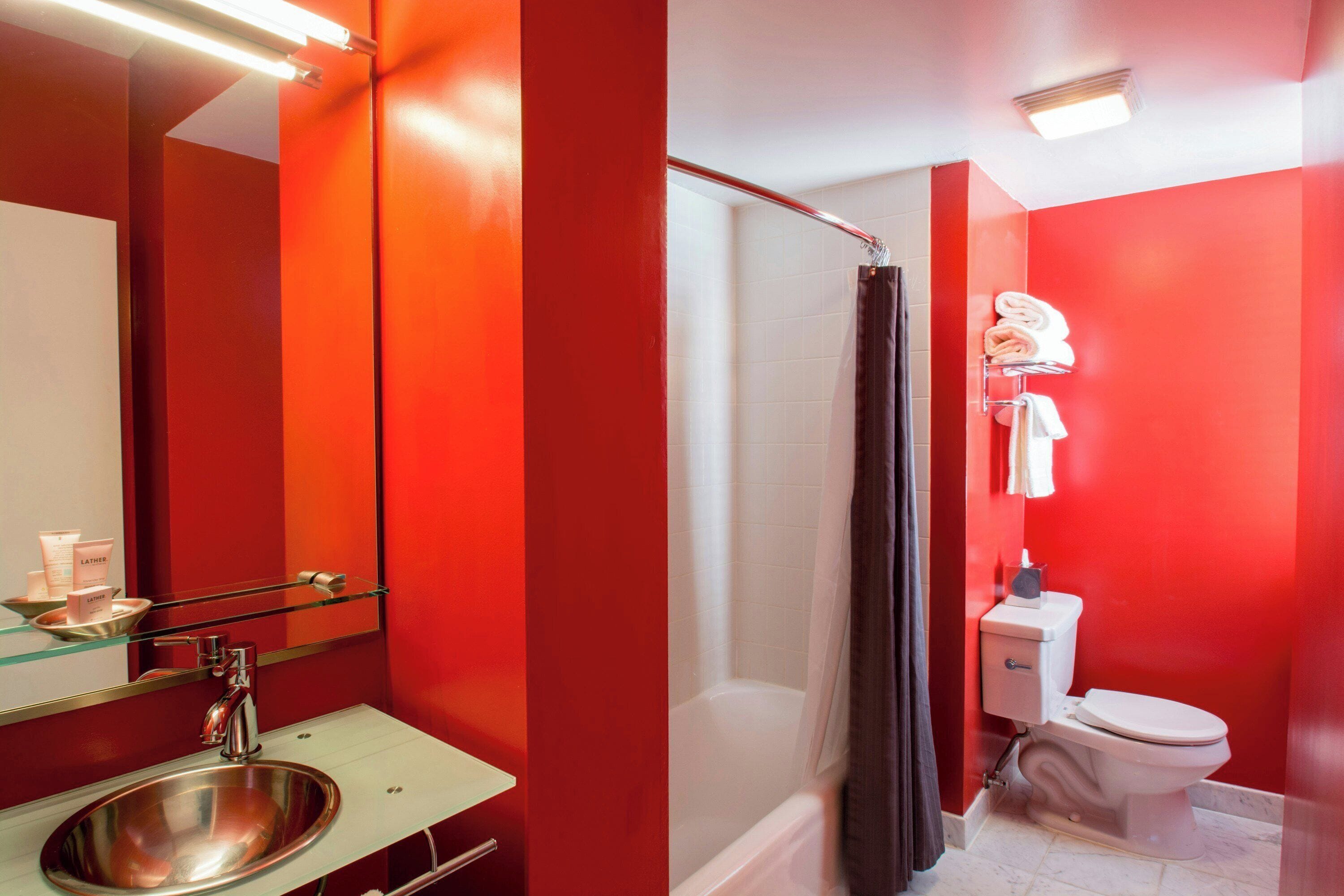 A bathroom with a glass sink, a shower, and a toilet.