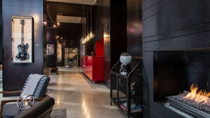 A modern lobby with a fireplace, a guitar display, and a reception desk. - Hotel Max (Seattle)