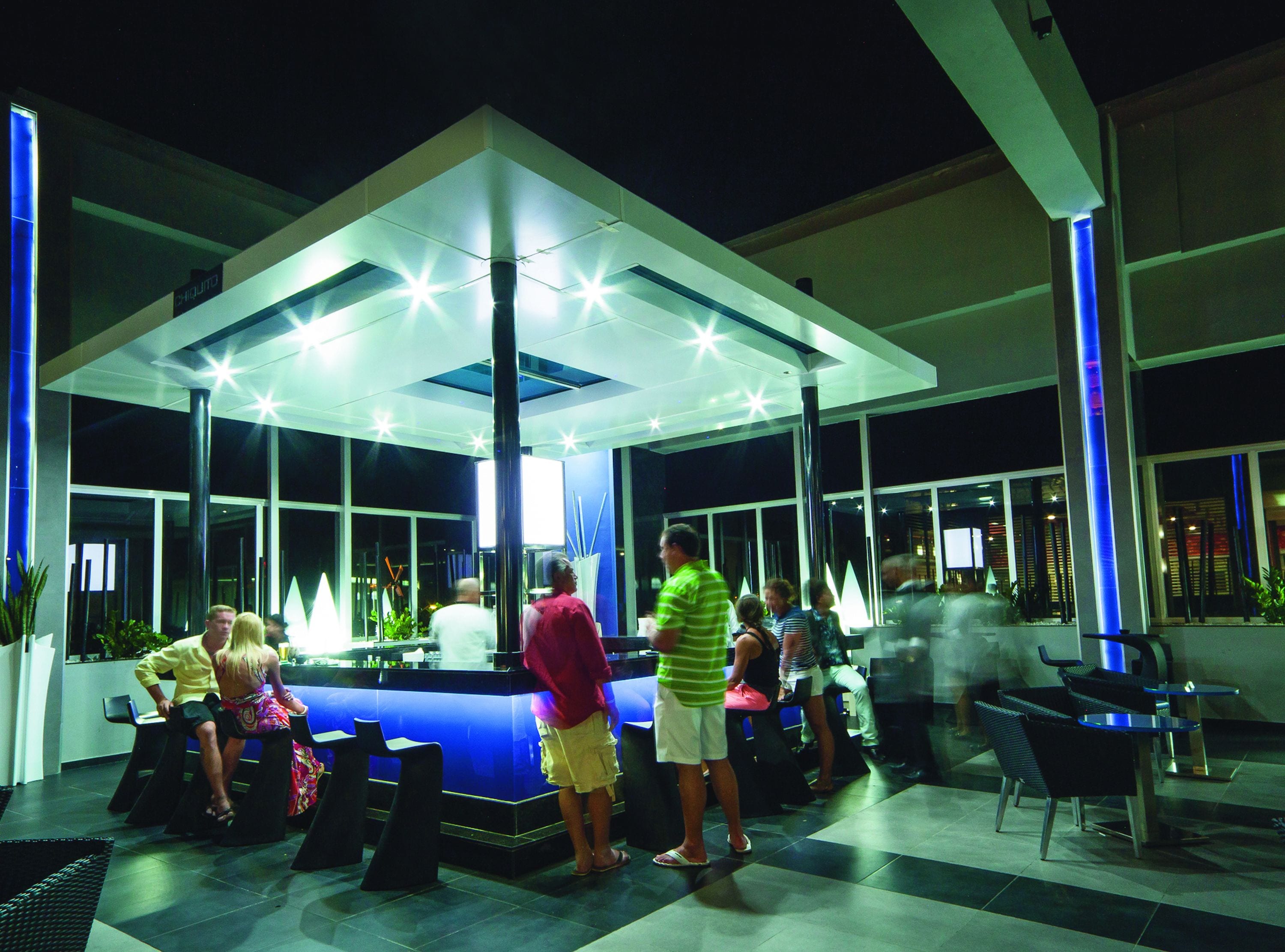 An outdoor seating area with a central water feature and a covered seating area.