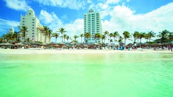 On the beach, white sand, sun loungers, beach umbrellas
