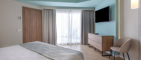 Une chambre d’hôtel moderne équipée d’un grand lit, d’un bureau, d’une chaise et d’un téléviseur fixé au mur.