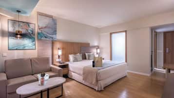 Una habitación de hotel moderna con una cama, un sofá, una mesita de noche y una mesa de centro.