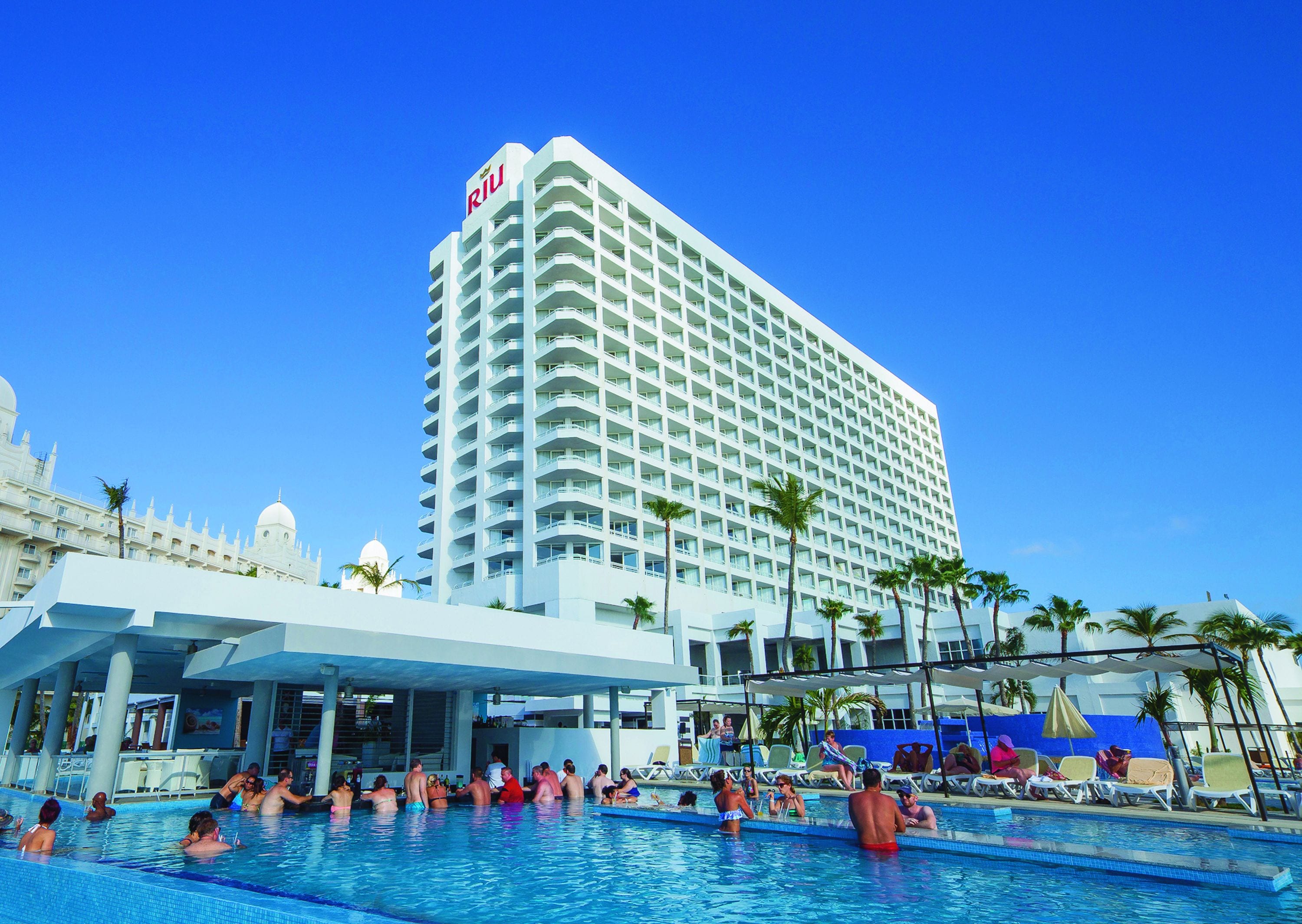 Un hotel con un amplio área de piscina, varios niveles y un letrero destacado que dice RIVIERA.