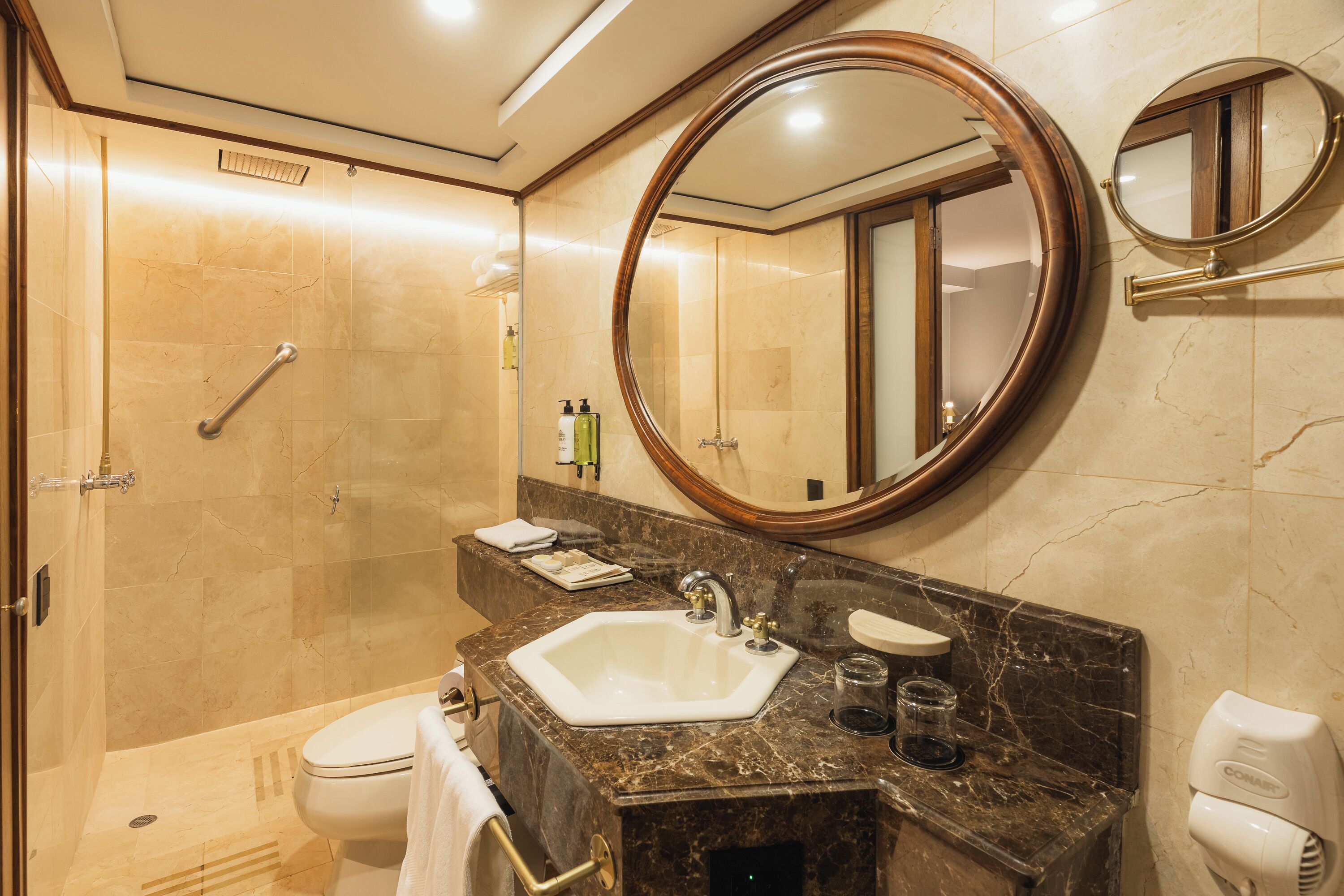 Un baño con lavamanos, espejo y ducha.