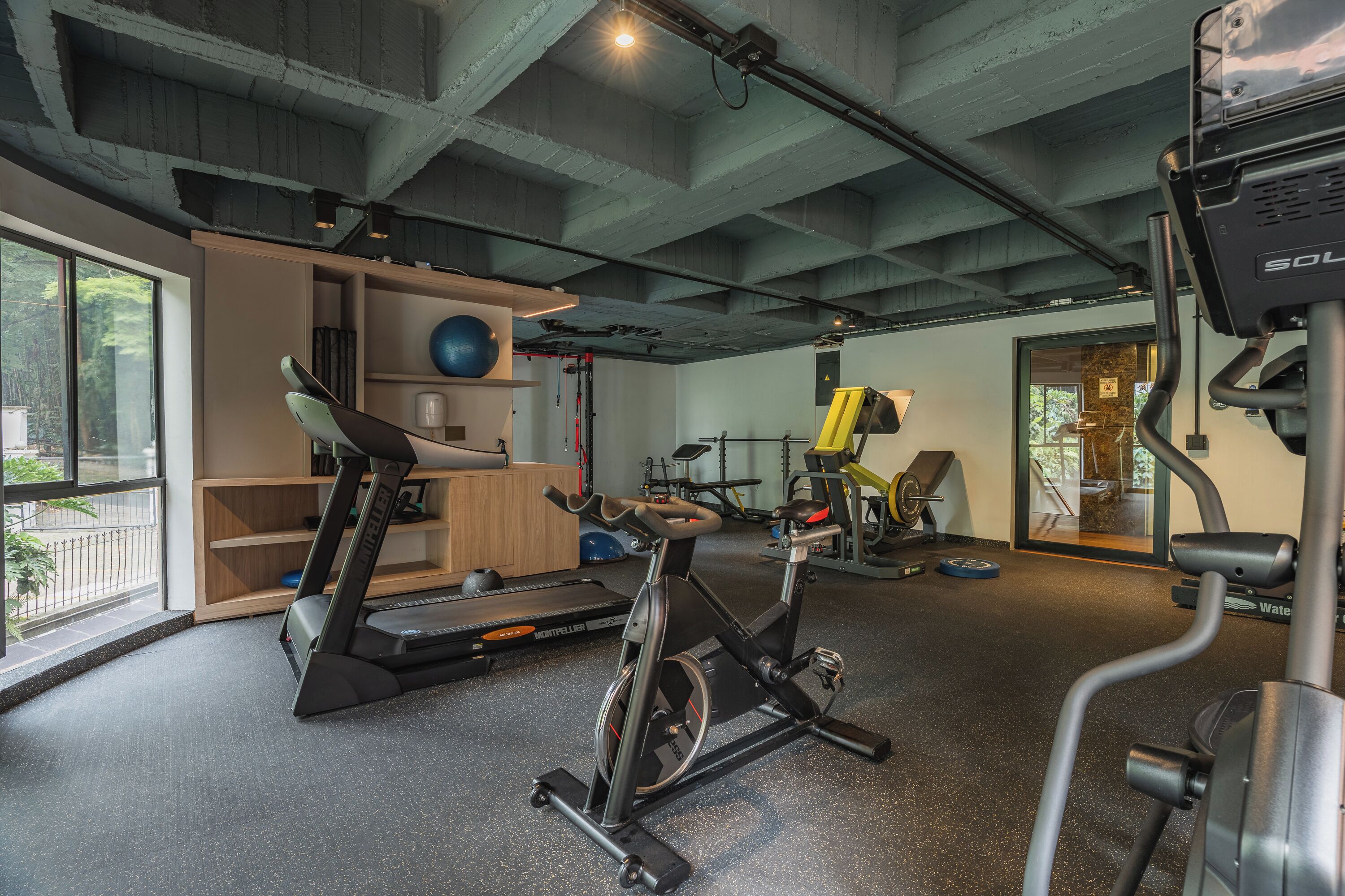 A gym with exercise equipment, a treadmill, and a stationary bike.