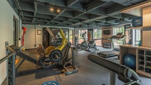 A gym with various exercise equipment, a treadmill, and a weight bench.