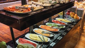 A buffet with various food items and utensils.