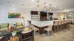 A spacious living area with a bar, seating, and a kitchen area. - Hilton Garden Inn Davis Downtown (Davis)
