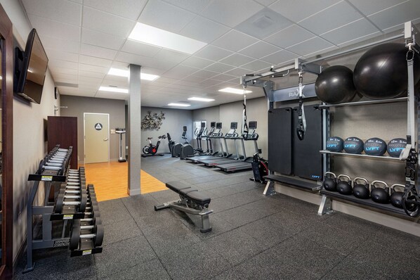 A gym with treadmills, elliptical machines, free weights, and exercise balls. - Hilton Garden Inn Davis Downtown (Davis)