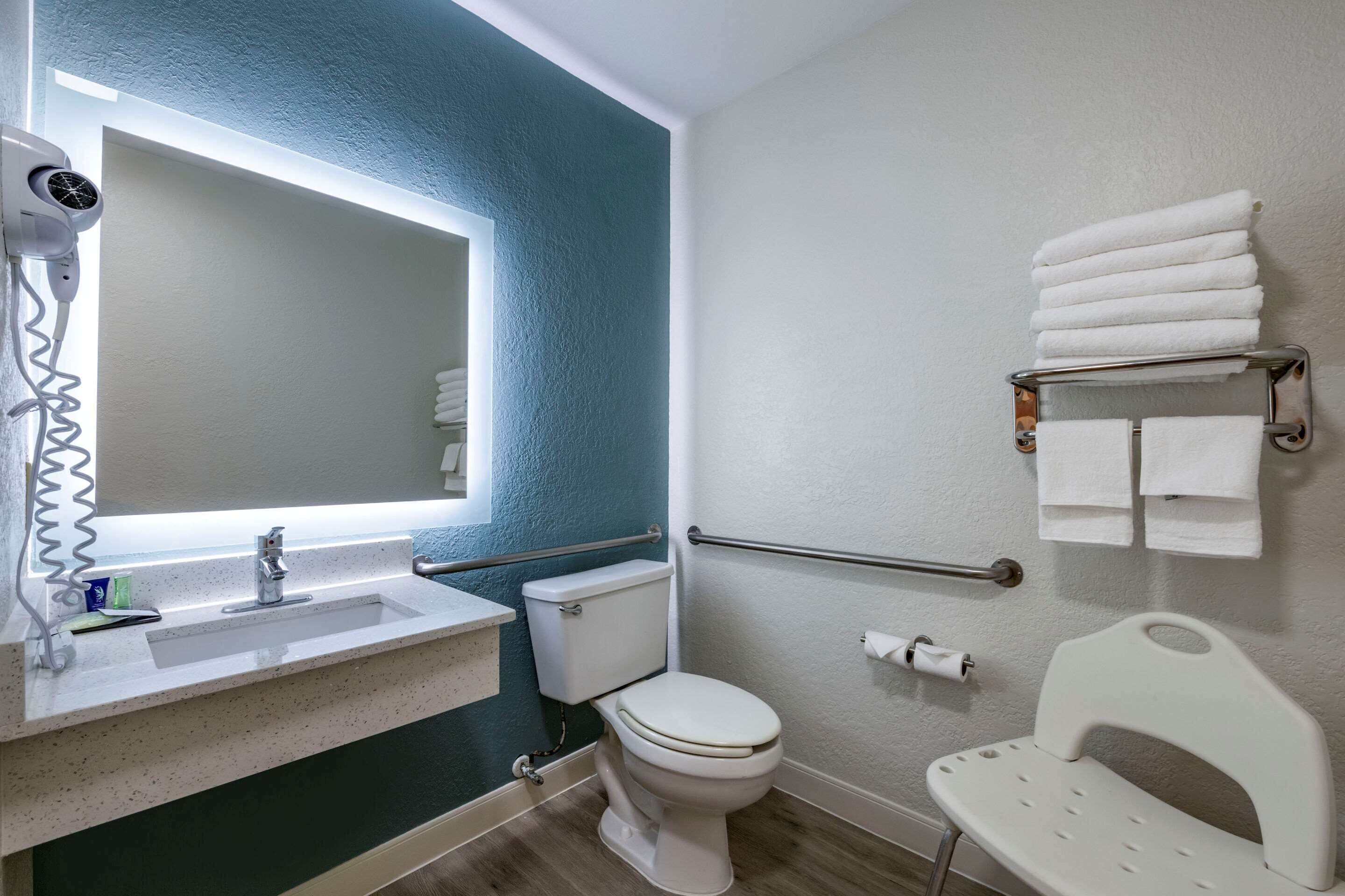 A bathroom with a sink, toilet, and hand dryer.