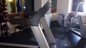 A gym with exercise equipment including a treadmill, stationary bikes, and a rowing machine. - Days Inn & Suites by Wyndham Greeley (Greeley)