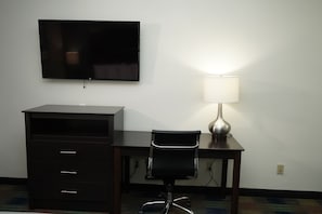 Una scrivania, postazione laptop, tende oscuranti, ferro/asse da stiro