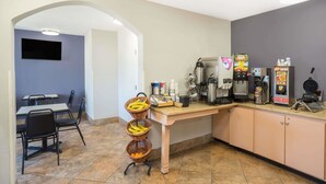 A kitchen area with a counter, coffee machines, and a seating area with chairs and tables. - Microtel Inn by Wyndham Bowling Green (Bowling Green)