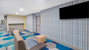 A modern hotel room with a large bed, a flat-screen TV mounted on the wall, and a patterned carpet. - Microtel Inn by Wyndham Athens (Athens)