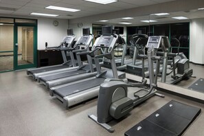 A gym with multiple treadmills, exercise bikes, and a mirrored wall. - Courtyard by Marriott Omaha Downtown (Omaha)