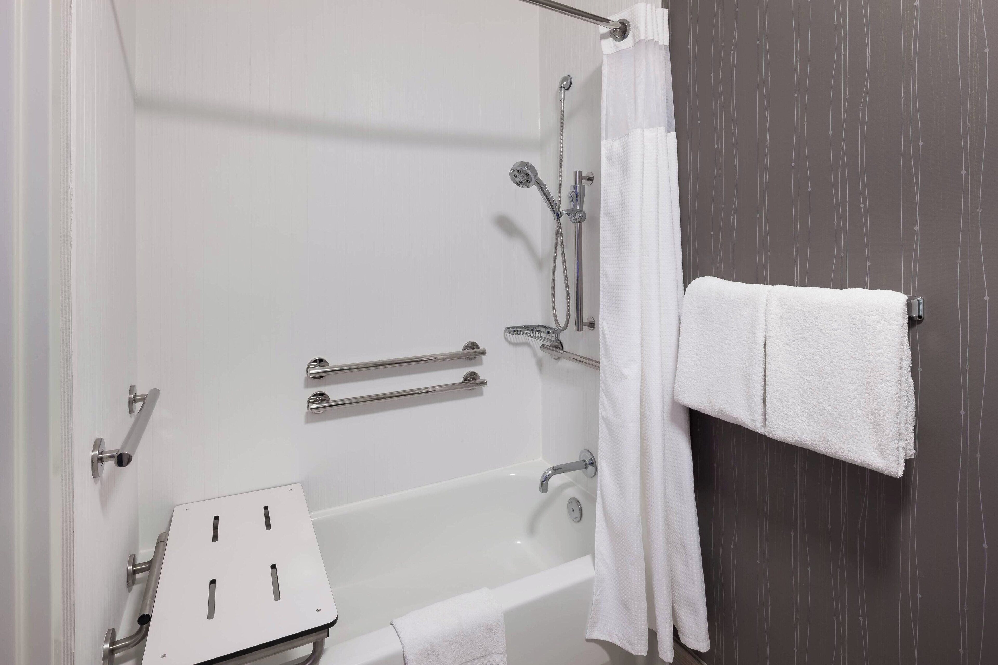 A bathroom with a bathtub, a shower, and a towel rack.