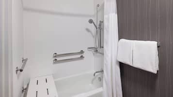 A bathroom with a bathtub, a shower, and a towel rack.
