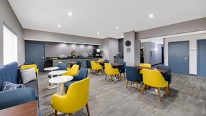 A modern hotel lobby with a dining area, a kitchen, and a reception desk. - Quality Inn & Suites Artesia (Artesia)