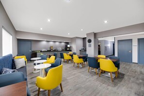 Eine moderne Hotelhalle mit Essbereich, Küche und Rezeption.