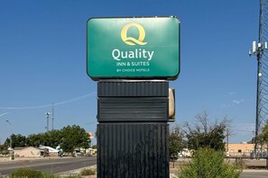 A sign for Quality Inn & Suites by Choice Hotels.