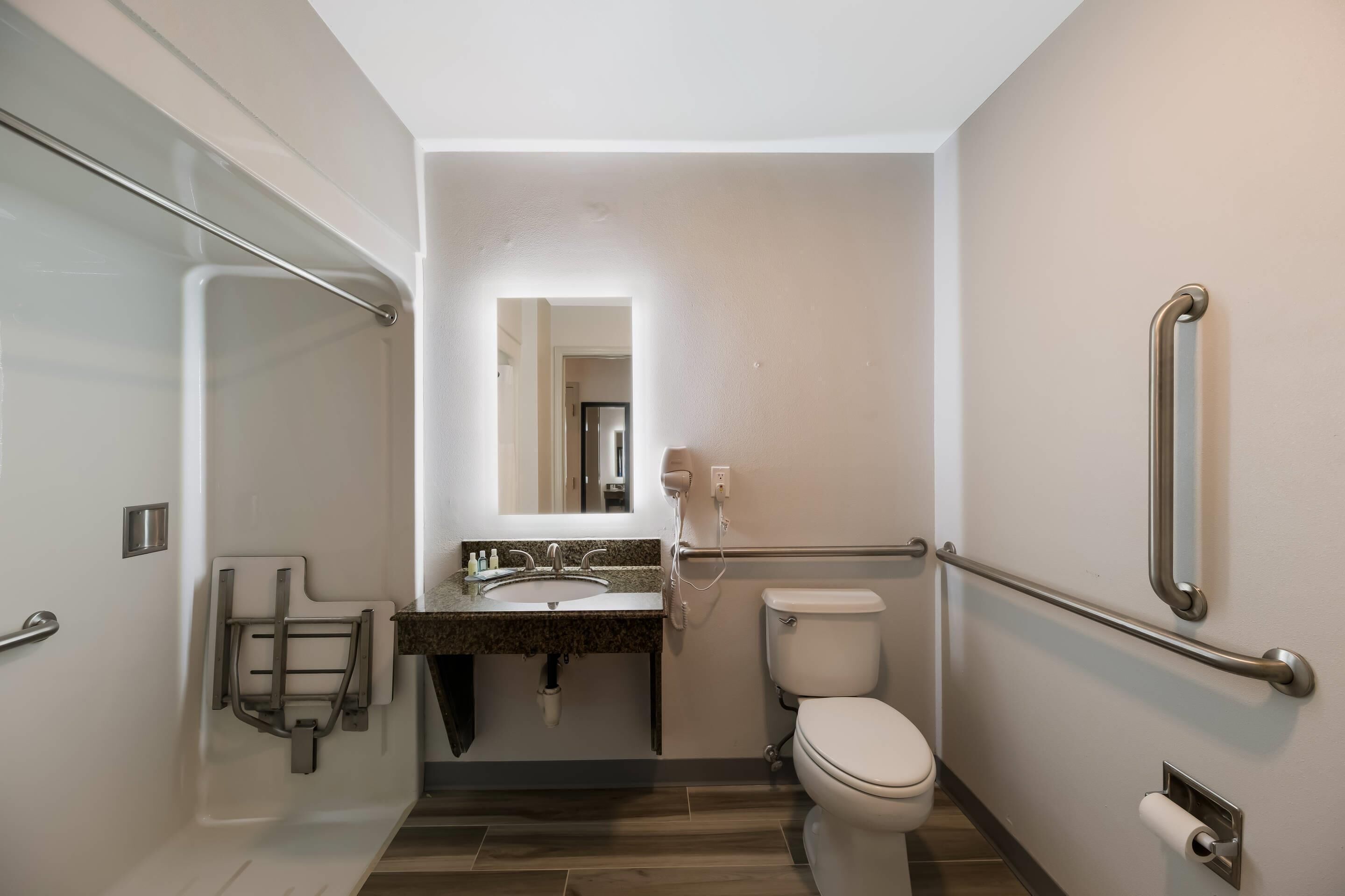 Een moderne badkamer met toilet, wastafel en douche.