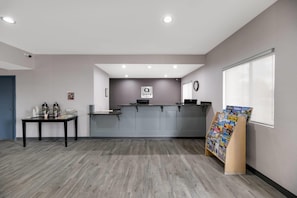 A reception area with a counter, a clock, and a magazine rack.