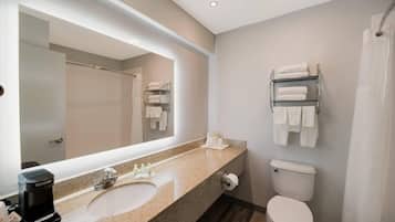 A modern bathroom with a large mirror, a sink, a toilet, and a shower curtain.