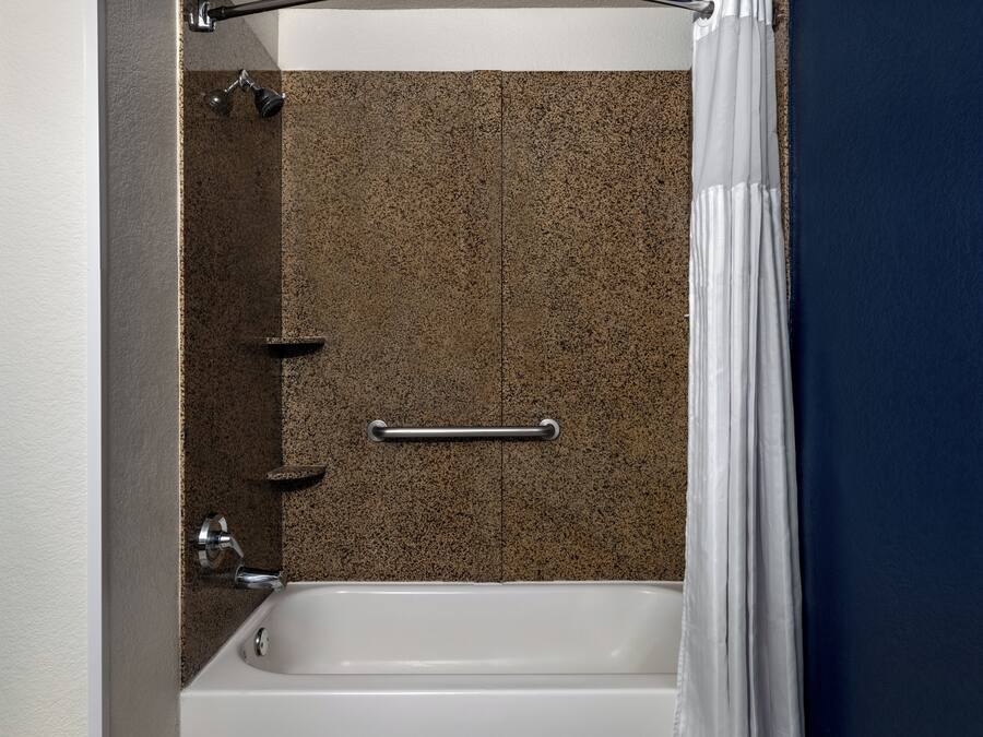 Un baño con bañera, ducha y toallero.