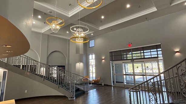 A spacious lobby with a grand staircase, modern chandeliers, and large windows. - Spark by Hilton Tempe Phoenix Airport (Tempe)