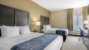 A hotel room with two beds, a desk, a chair, a lamp, and a window with curtains. - Comfort Inn St. Robert / Fort Leonard Wood (St. Robert)