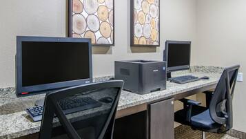 A computer desk with two monitors, a printer, and a keyboard.