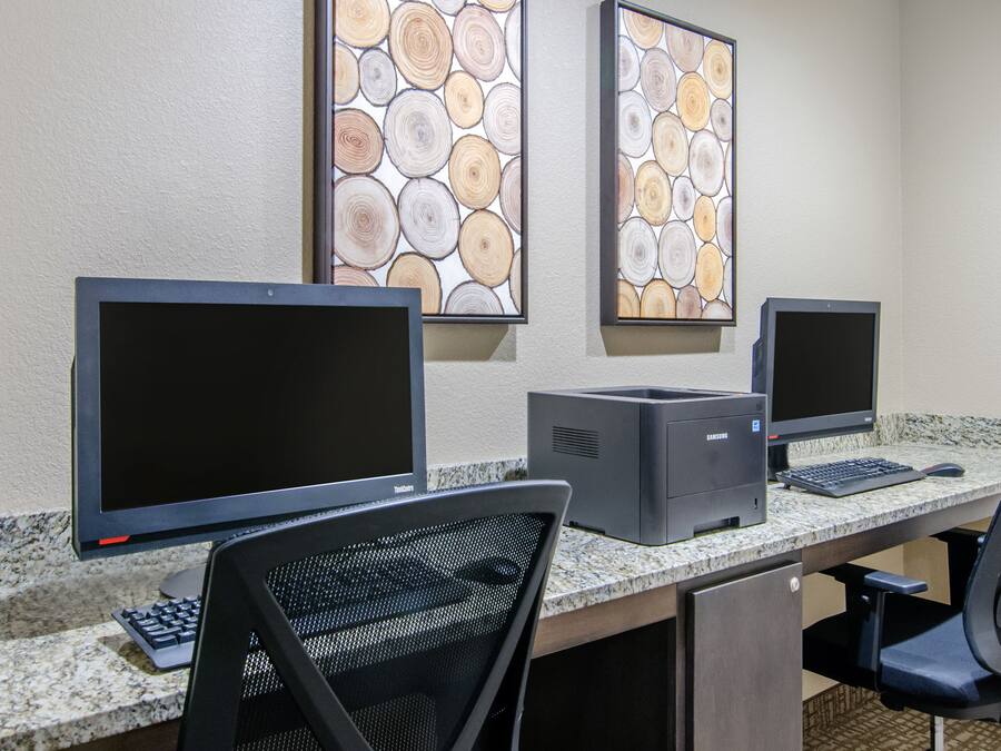 A computer desk with two monitors, a printer, and a keyboard.