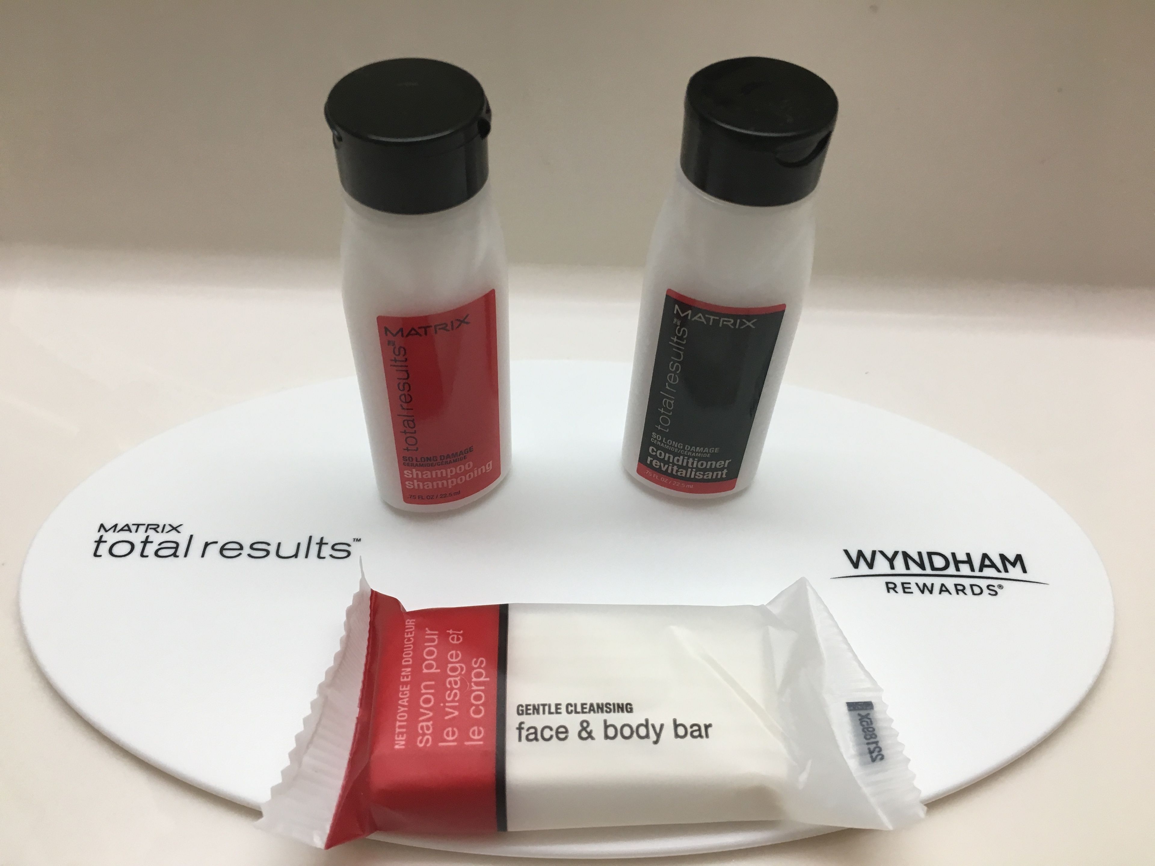 Two bottles of MATRIX total results shampoo and conditioner, and a face & body bar on a white plate.