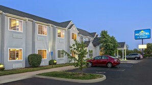 A Microtel Inn & Suites by Wyndham with a parking lot and a red car parked in front. - Microtel Inn & Suites by Wyndham Mason/Kings Island (Mason)
