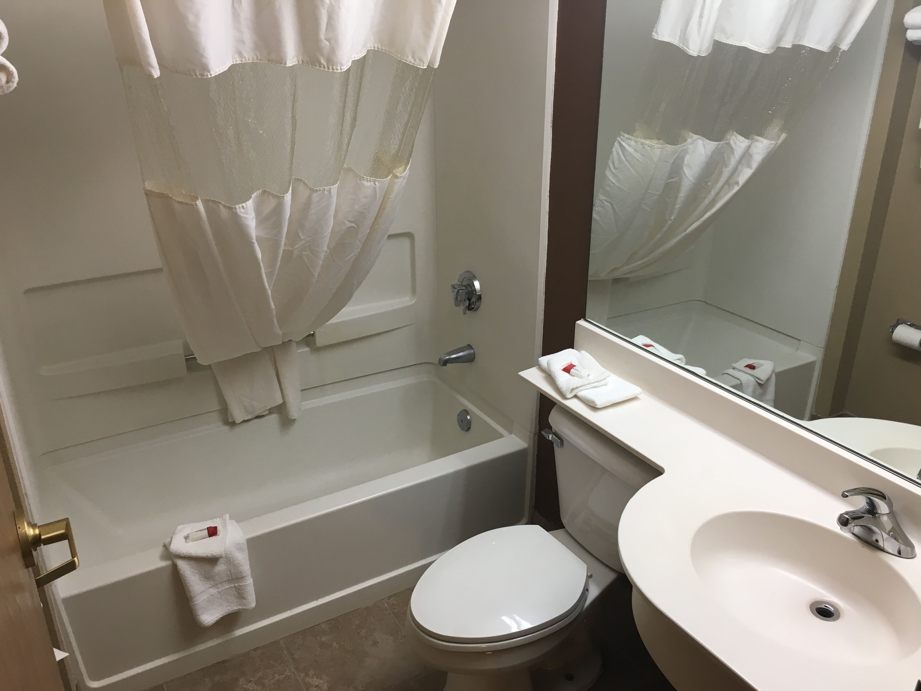 A bathroom with a bathtub, toilet, and sink.