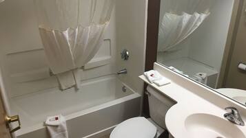 A bathroom with a bathtub, toilet, and sink.