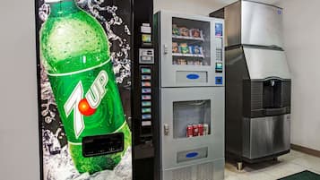 Una máquina expendedora de 7UP y un refrigerador de acero inoxidable en una habitación.