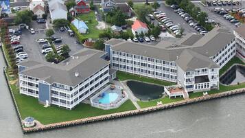 Un hotel frente al agua con varias construcciones, una piscina y un muelle.