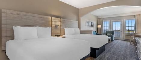 Ein Hotelzimmer mit zwei Betten, einem Schreibtisch und einem Stuhl.