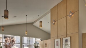 A modern hotel lobby with a reception desk, seating area, and large windows offering views of the outdoors. - Corporate Inn Sunnyvale (Sunnyvale)