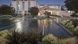 A hotel with a modern architectural style, featuring a spacious parking lot and well-maintained landscaping. - Corporate Inn Sunnyvale (Sunnyvale)
