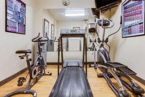 A gym with cardio equipment including treadmills, stationary bikes, and elliptical machines.