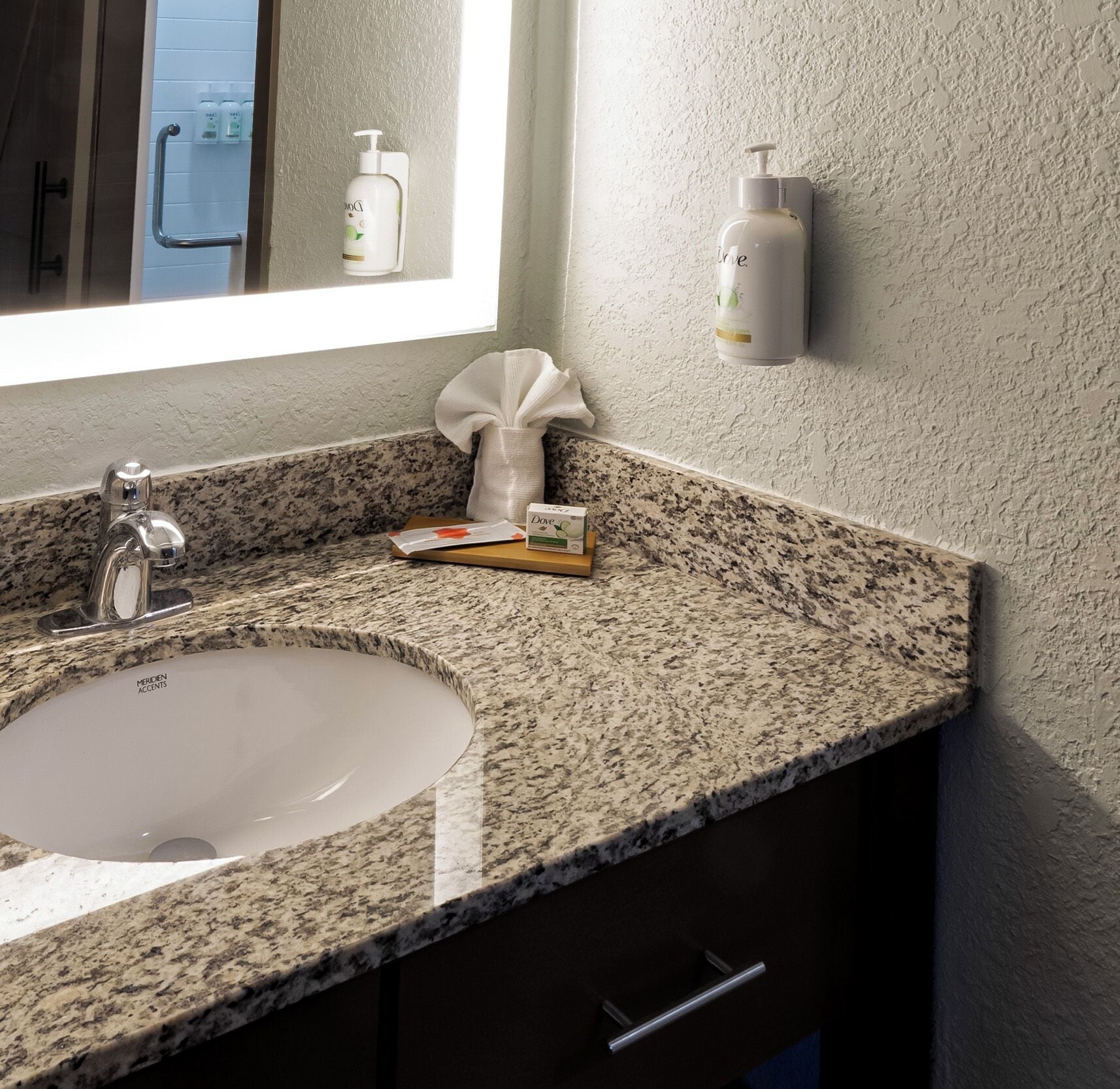 A bathroom with a granite countertop, a white sink, and a window.