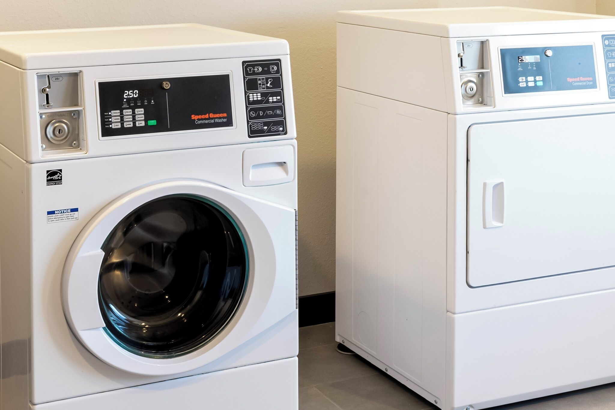 Two white front-loading washing machines with digital displays and control panels.